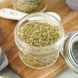 A mason jar with homemade italian seasoning in the jar.