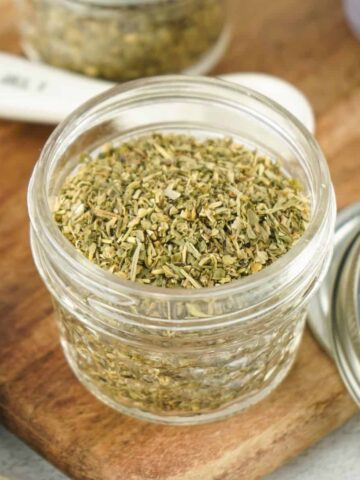 A mason jar with homemade italian seasoning in the jar.