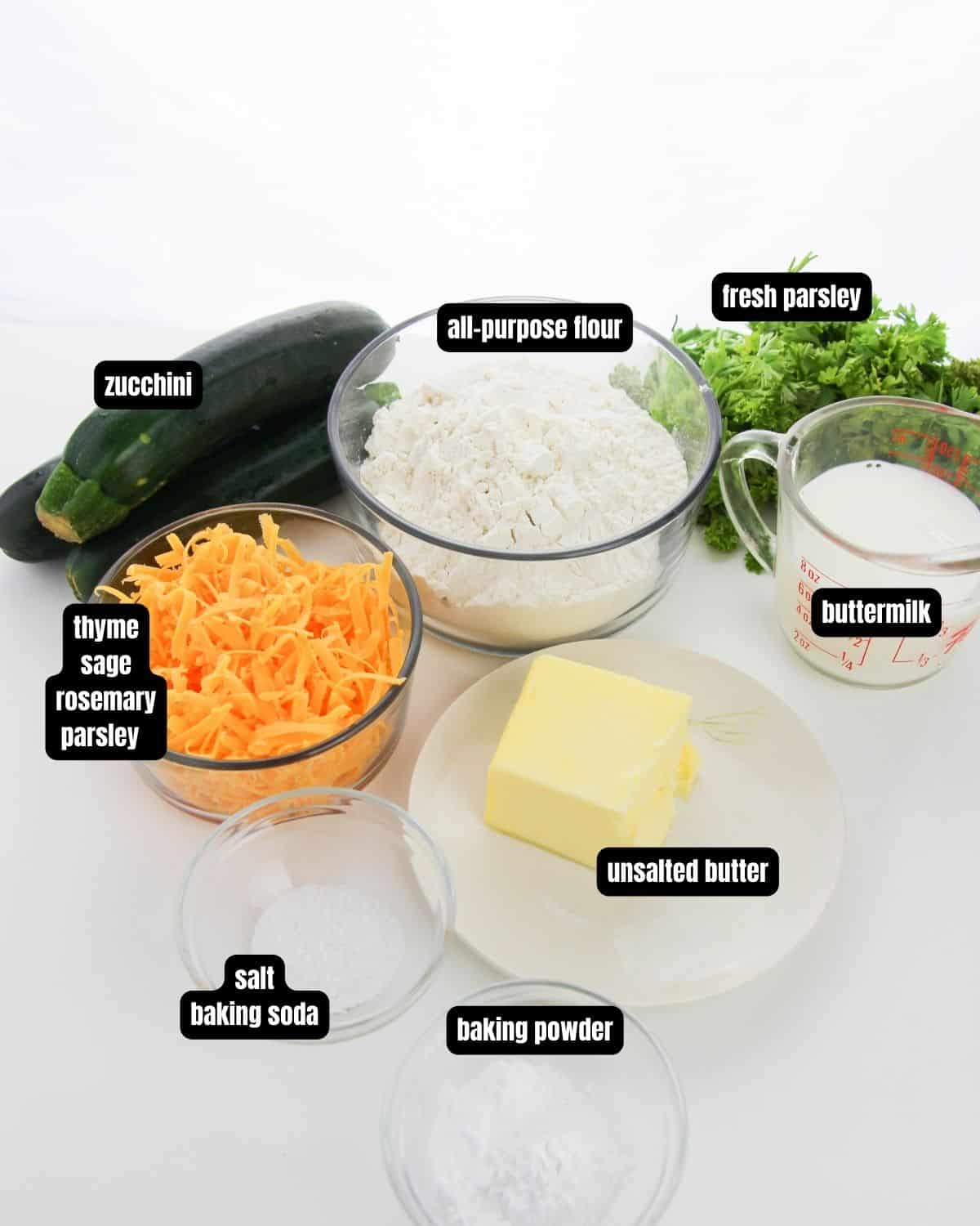 Ingredients with text overlay of zucchini cheddar biscuits