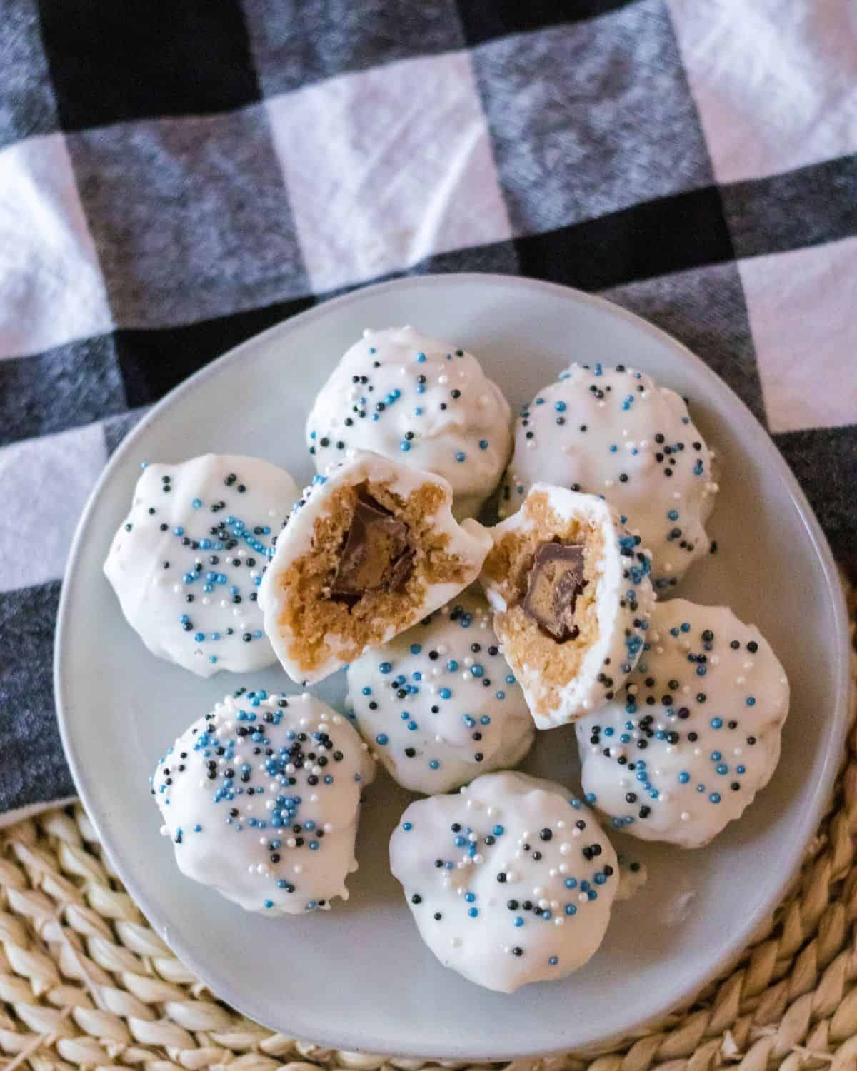 An overhead view of no bake crispy rice crispy peanut butter balls in white chocolate and blue sprinkles.