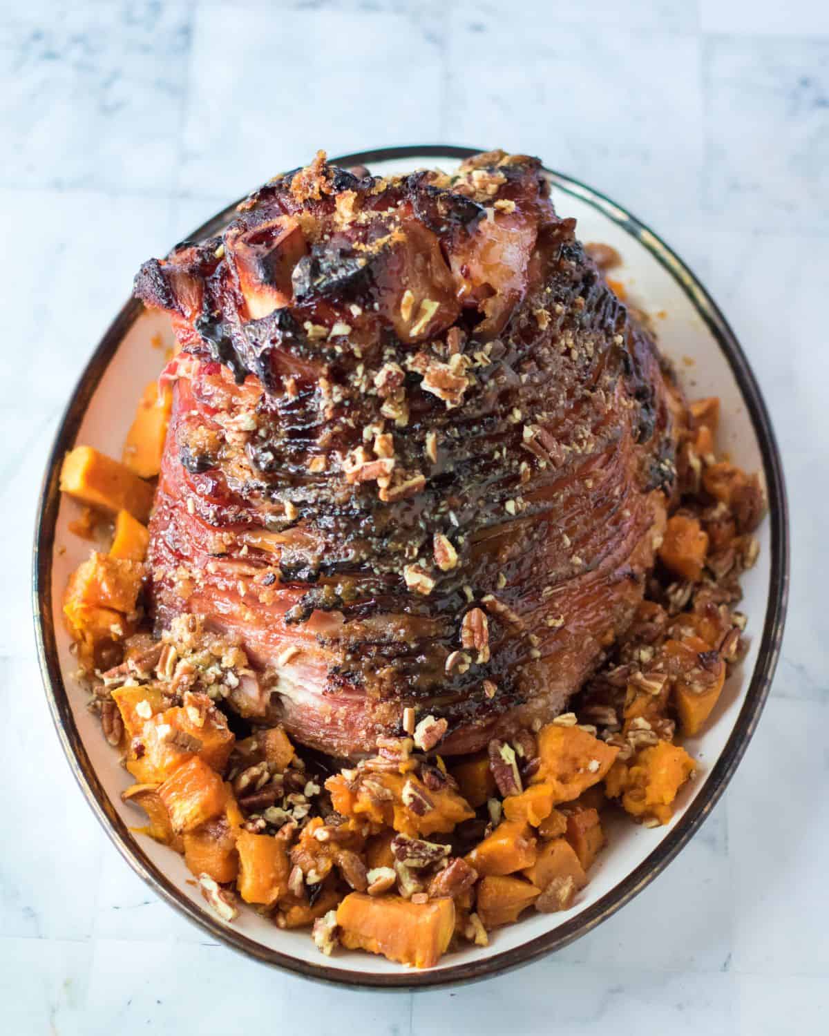 An overhead view of a glazed spiral ham with a pecan praline coating.