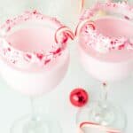 Peppermint cocktail with a candy cane garnish and a crushed candy cane trim.