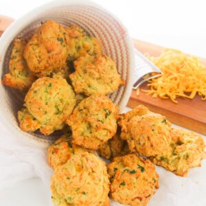 A basket filled with drop biscuits made with zucchini and cheddar.