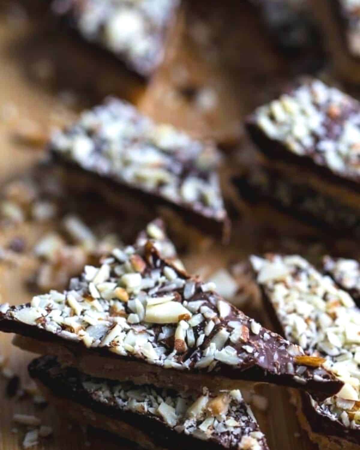 Pieces of homemade almond roca on a wooden board.