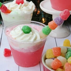 A glass of sherbet punch topped with whipped cream and gumdrops.