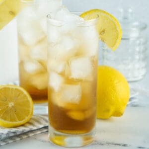 A long island iced tea beverage in a tall glass with ice.