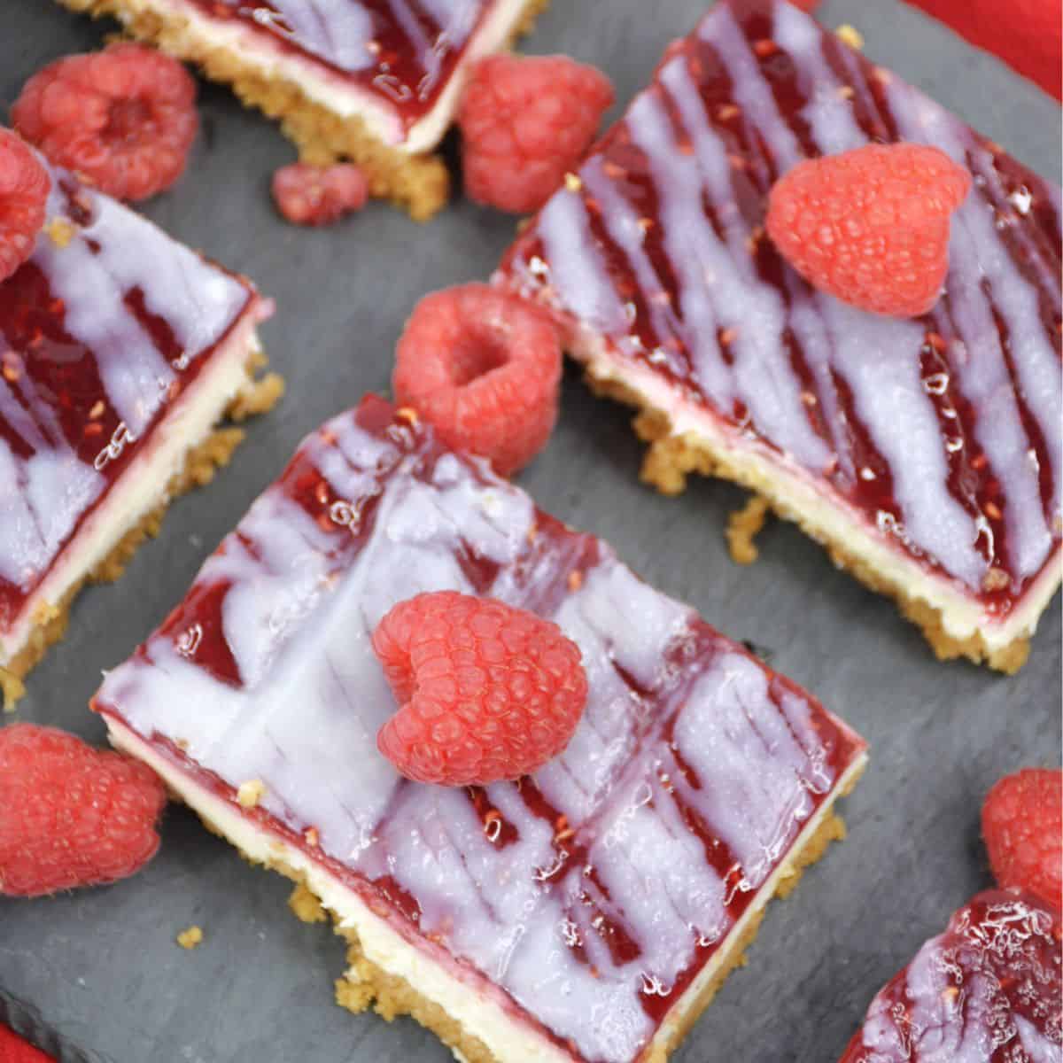 Raspberry white chocolate cheesecake bars with a raspberry glaze.