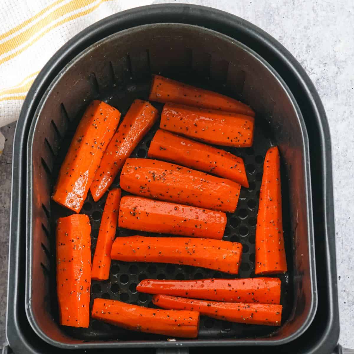 Air fryer carrots seasoned and in the air fryer basket. 