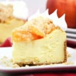 A slice of peach cheesecake with a peach cobbler topping.