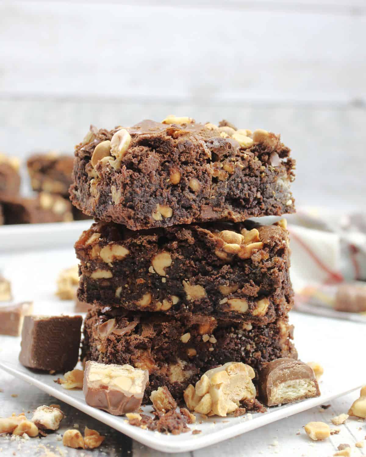 A stack of snicker peanut candy brownies.