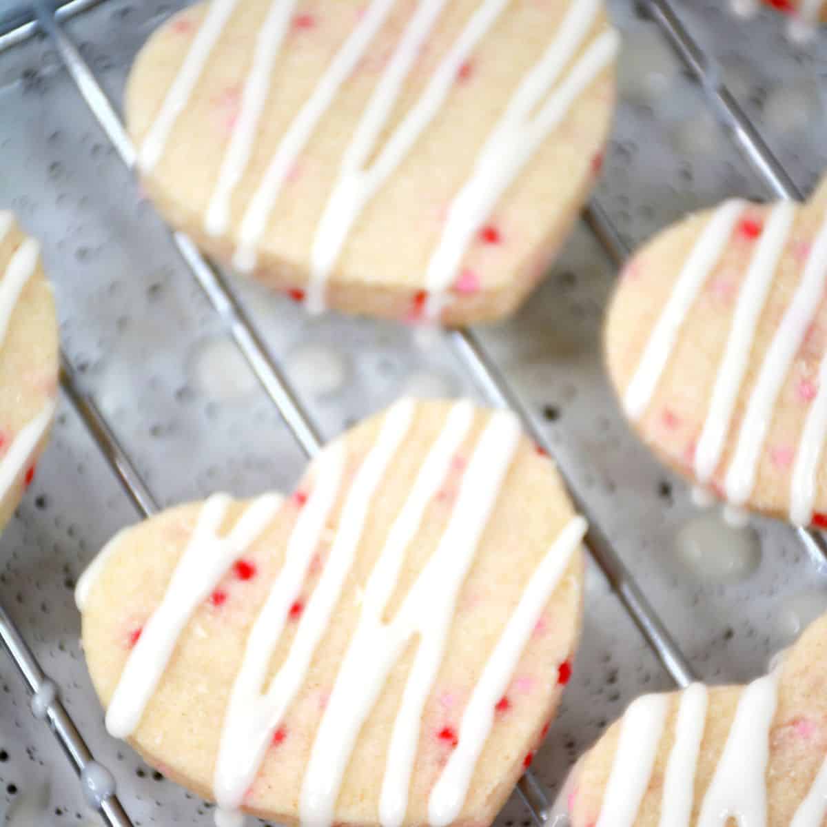 Heart cookies with white icing drizzled on the cookies. 