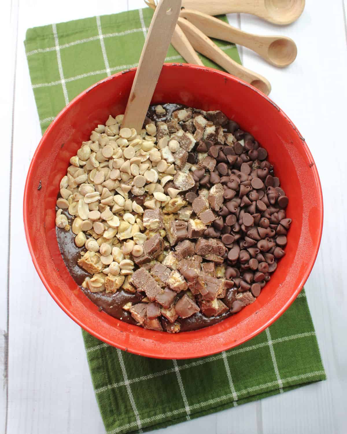 Candy bars, chocolate being mixed together in a bowl to make candy bar brownies. 