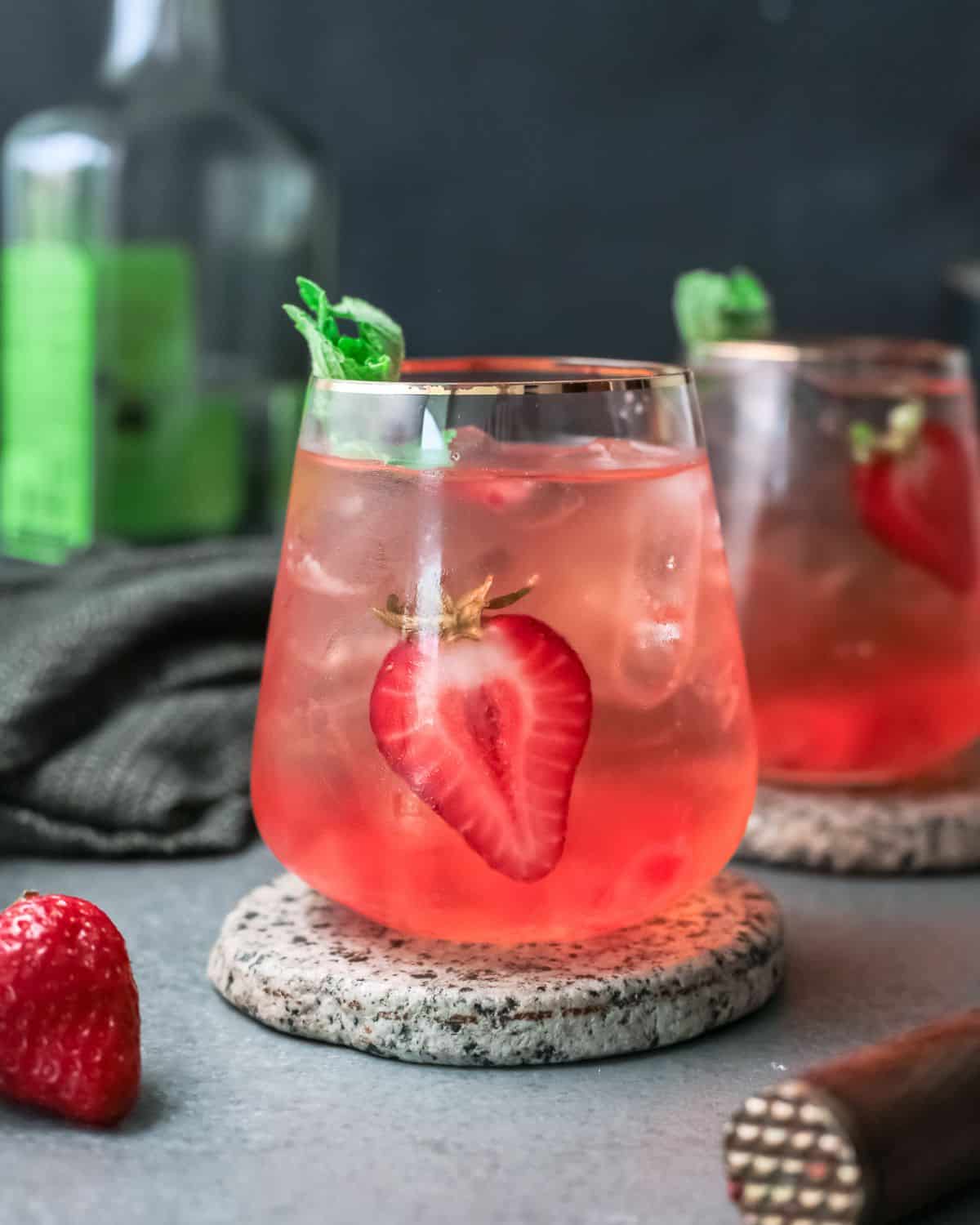 A beverage with ginger beer, sparkling soda and strawberries.