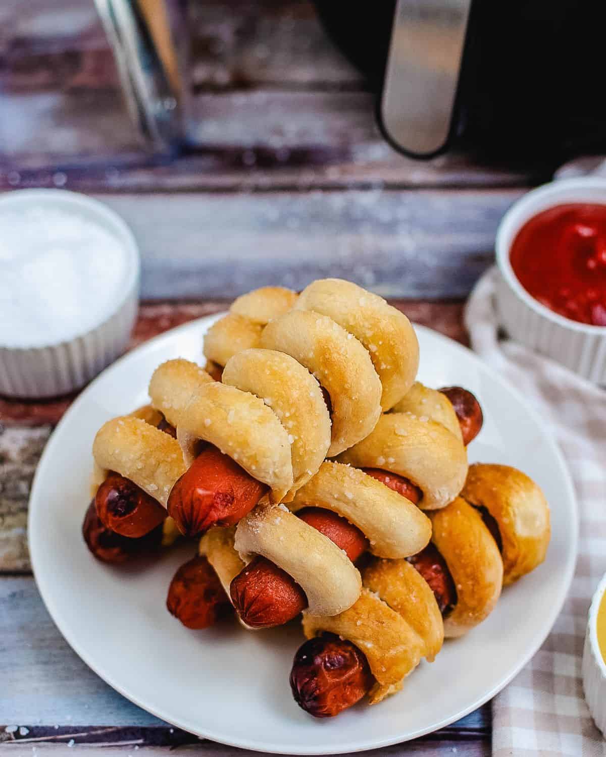 Stacked hot dogs in pretzel buns. 