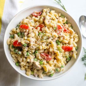 A cold tuna and pasta salad with tuna, pasta, tomatoes, and peas.