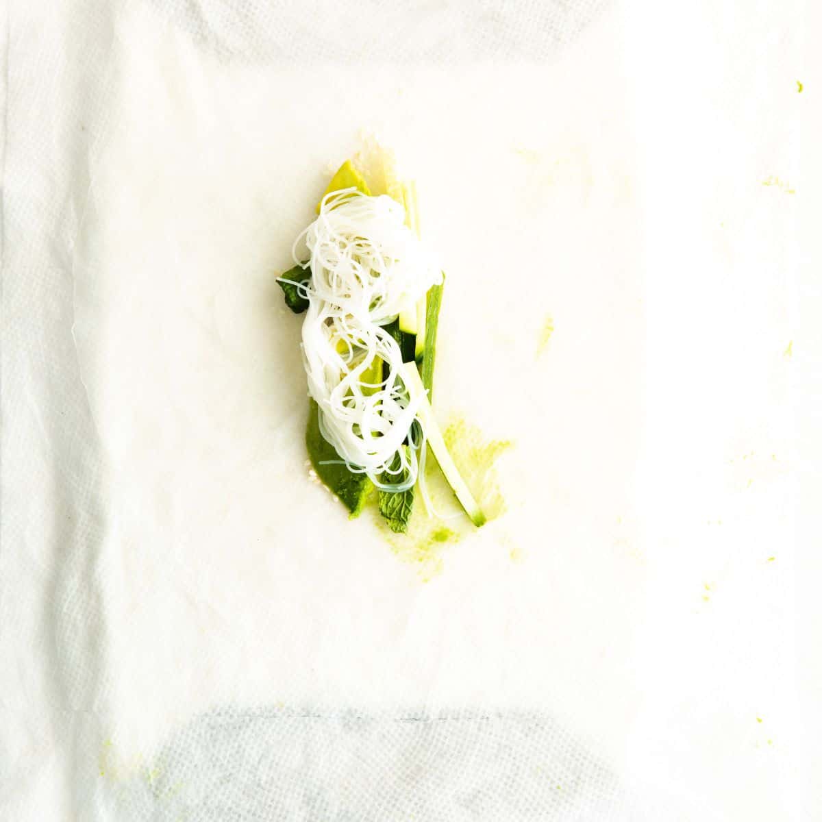 A rice wrapper with avocados and rice noodles.