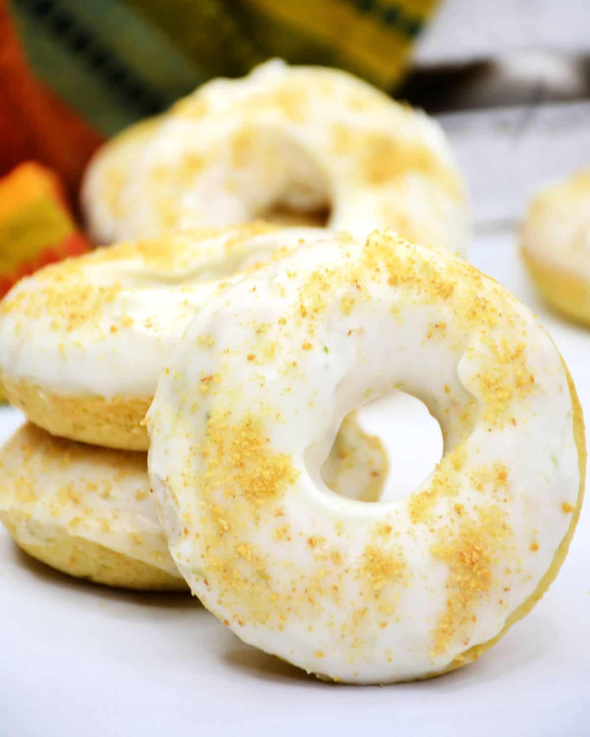 Homemade key lime pie donuts with a lime glaze stacked up.