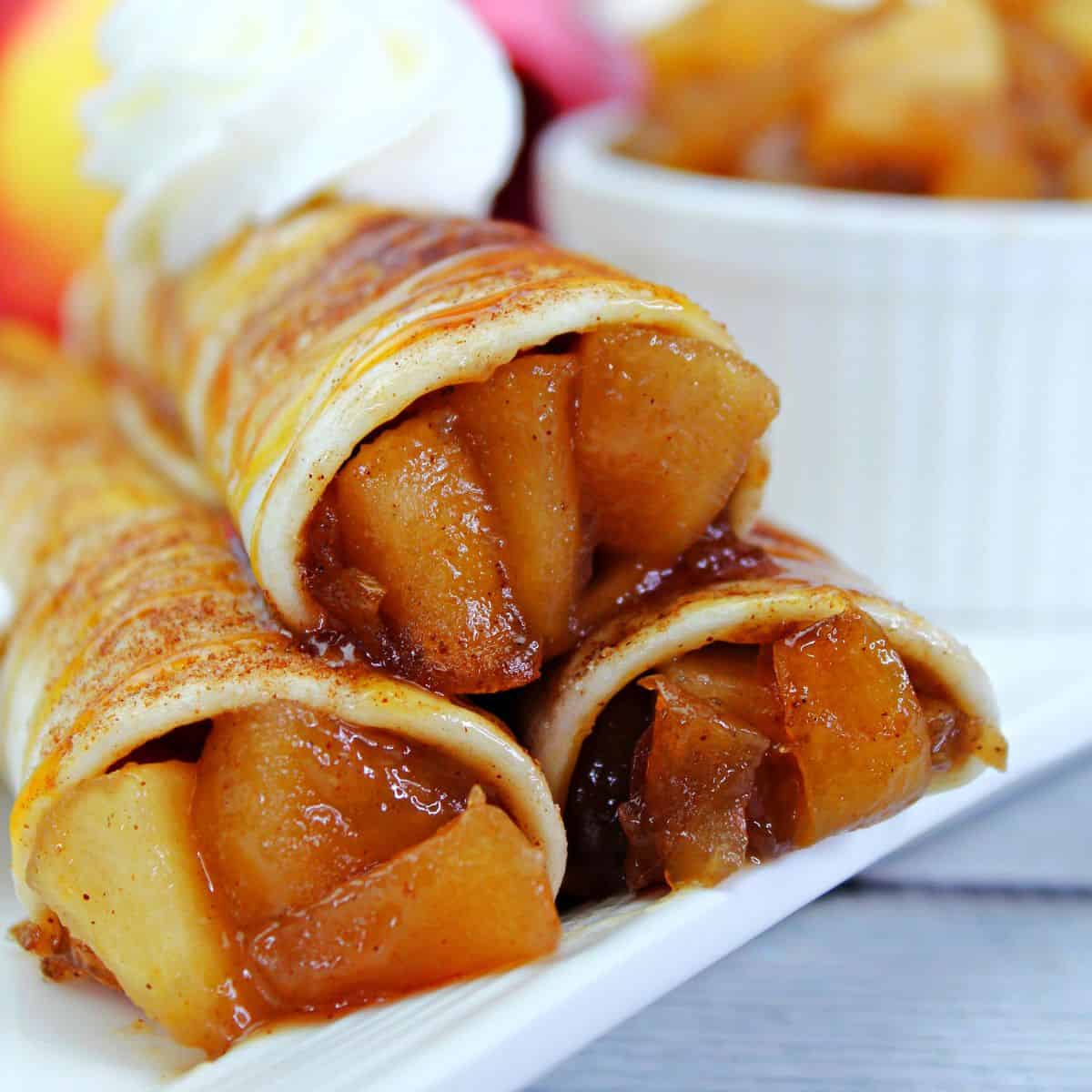 A stack of Mexican tortillas stuffed with apple pie filling to make apple pie taquitos.