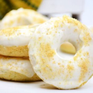 Key lime donuts with a lime glaze stacked up on a plate.