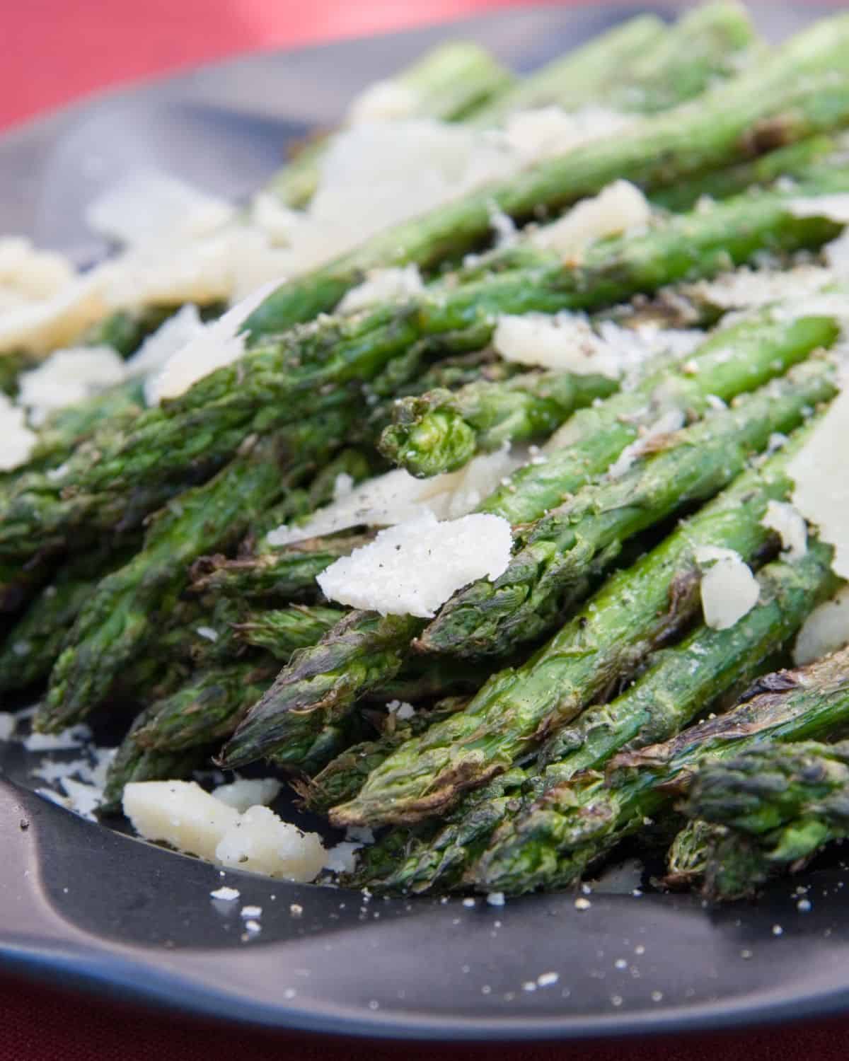 Grilled asparagus topped with parmesan cheese chunks.