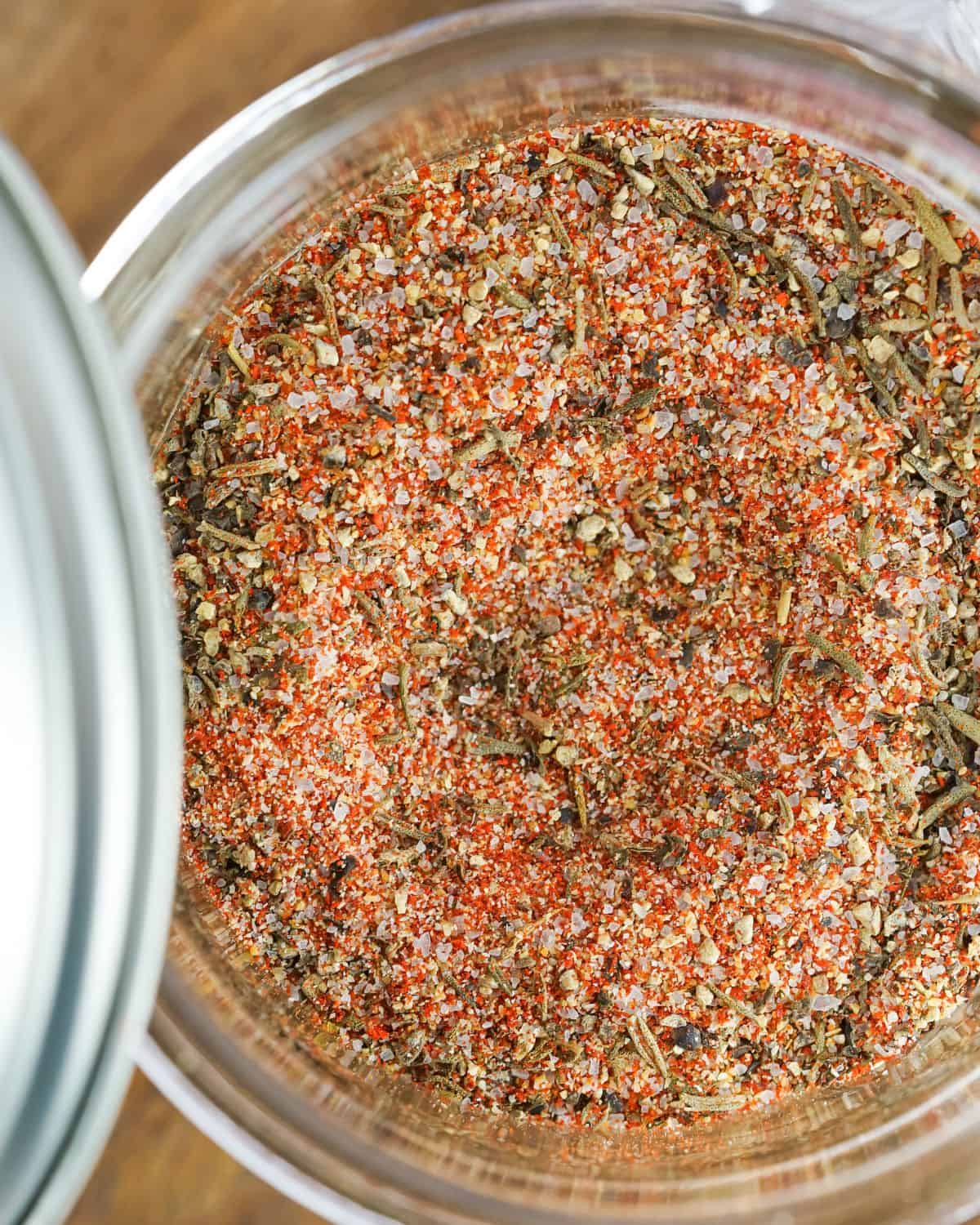 A glass jar with steak seasoning in the jar. 