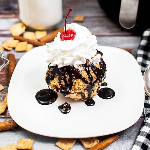 Fried ice cream on a plate with chocolate and whipped cream.