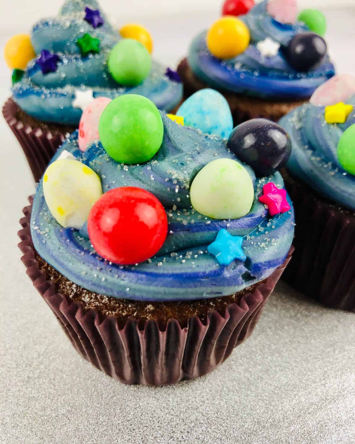 Chocolate cupcakes decorated with the galaxy theme. 