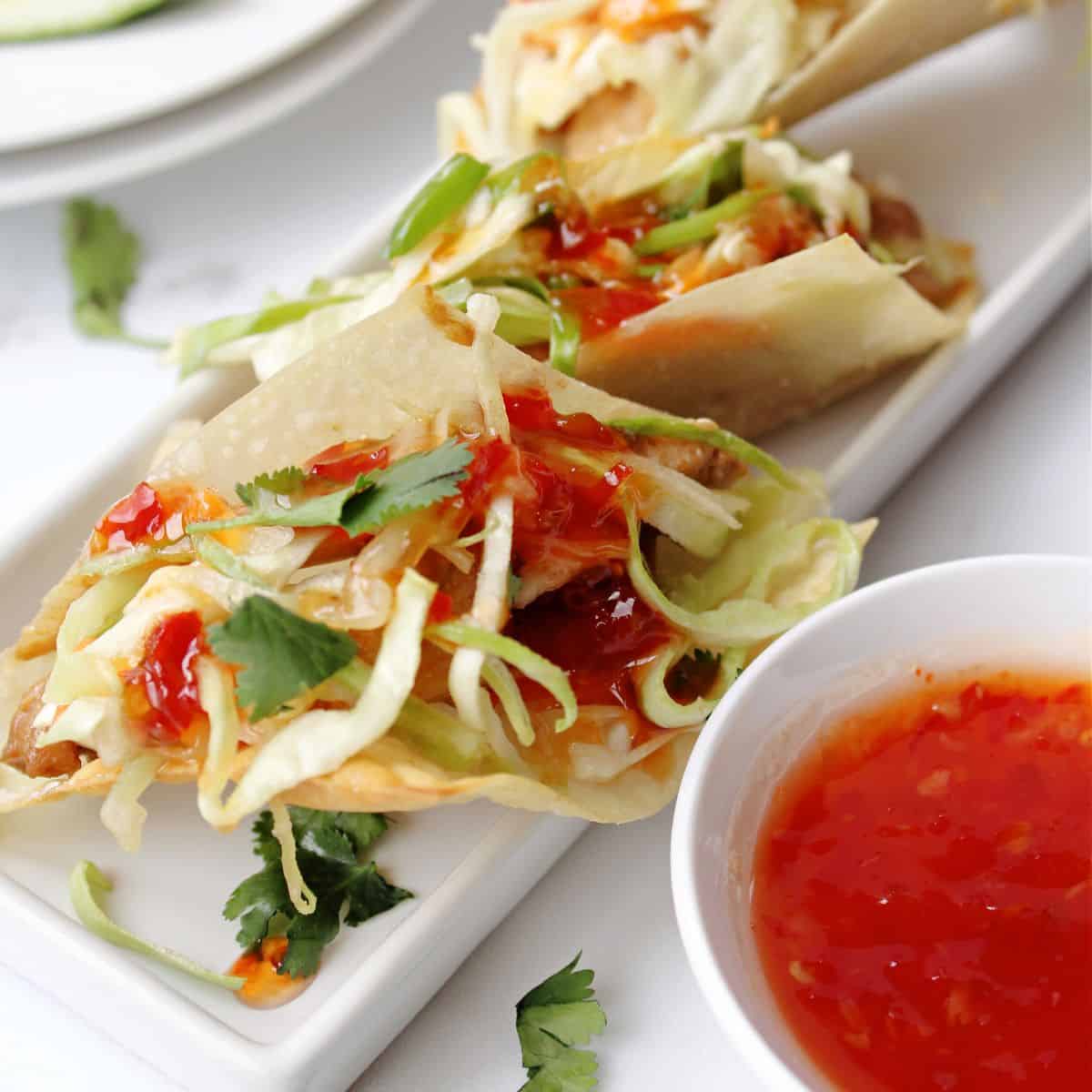 Wonton tacos on a white plate.