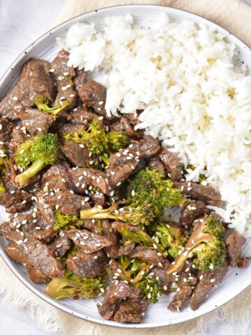 An overhead view of Chinese beef and broccoli served with rice.