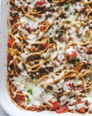 Baked spaghetti topped with mozzarella cheese.