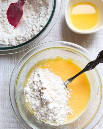 A glas bowl with eggs and flour to make a pineapple upside down cake.