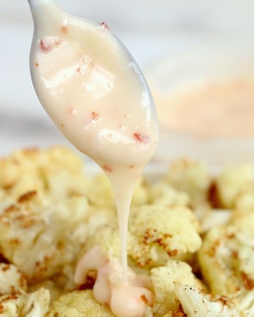 Bang bang sauce being drizzled on cauliflower that was air fried.