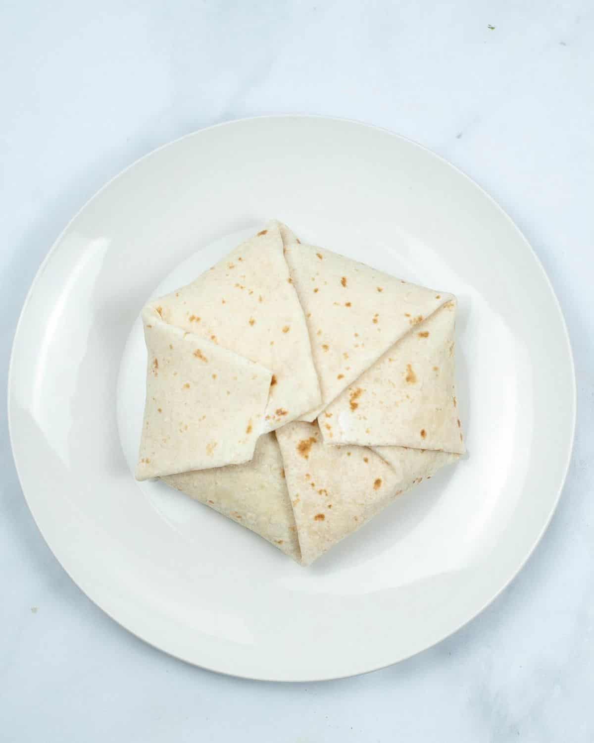 A flour tortilla that has been folded up to air fried to make a crunch wrap supreme.