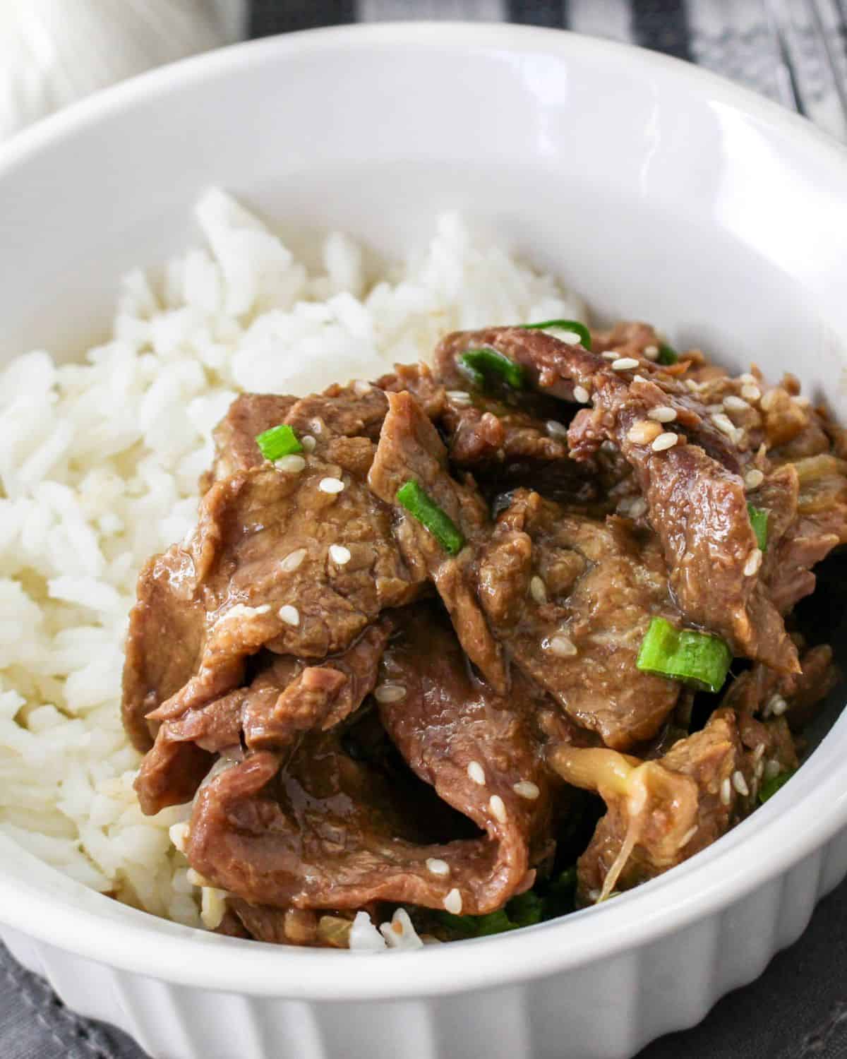 Korean beef and rice in a bowl topped with sesame seeds.