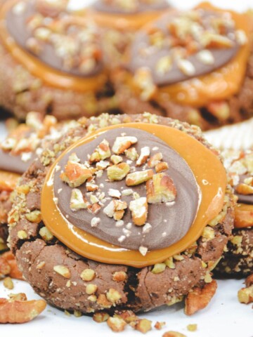 Copycat crumbl turtle cookies with nuts and a caramel center.