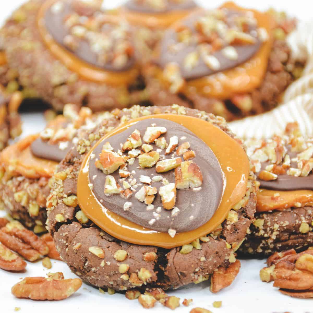 Copycat crumbl turtle cookies with nuts and a caramel center.