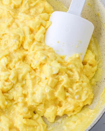 Scrambled eggs in a saute pan to make egg pizza bagels.