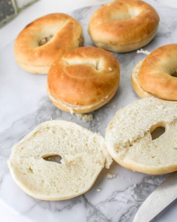 Sliced bagels on a platter to make pizza bagels with eggs.
