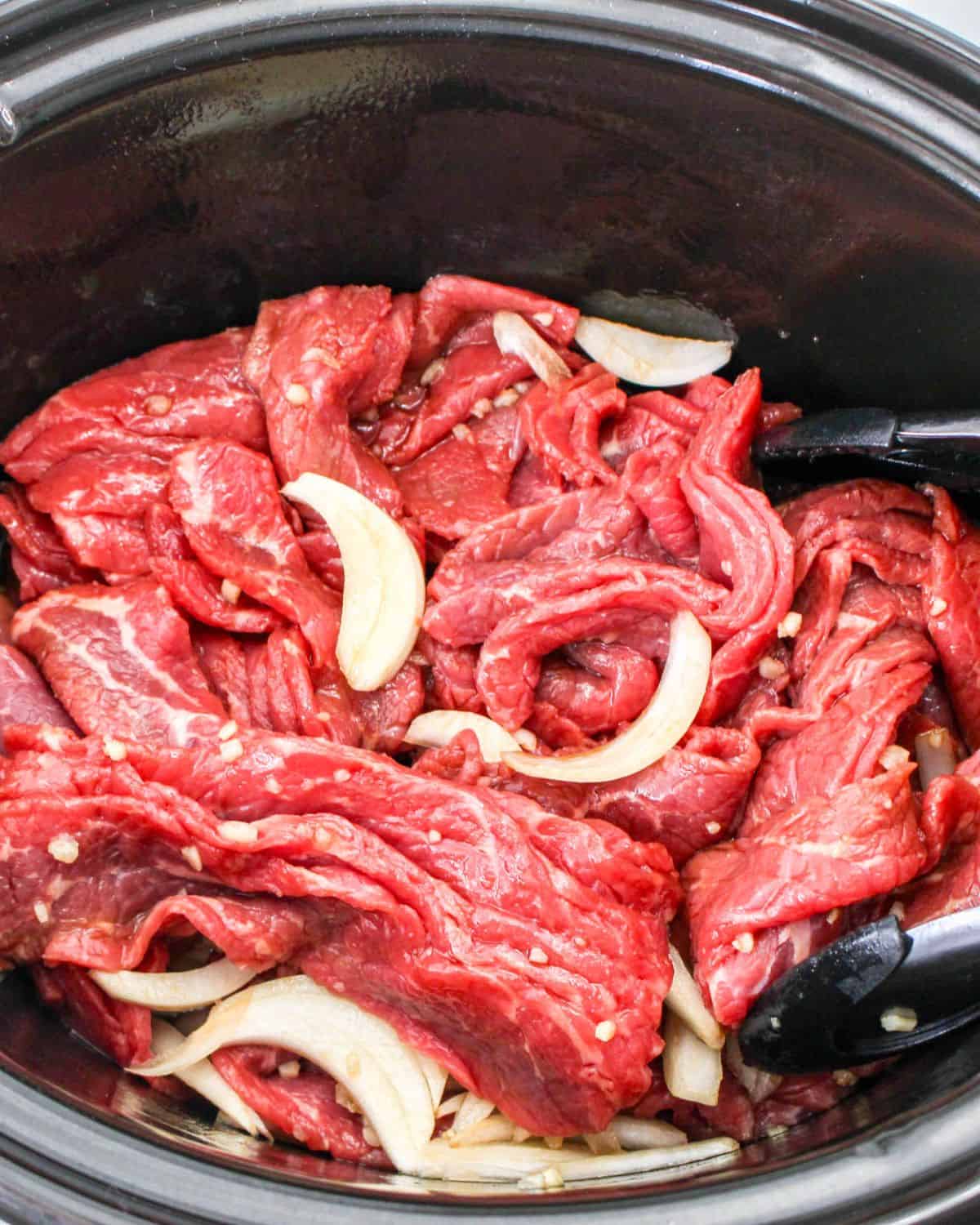 Beef, onions, and a marinade to make a Korean beef in the slow cooker.