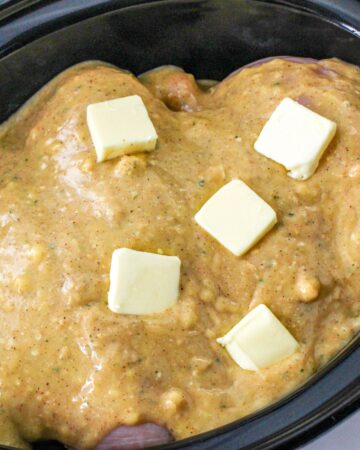 Chicken and potatoes topped with cream of chicken soup and pats of butter.