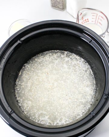 Water in the slow cooker with grits to make crockpot grits.