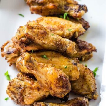 A stack of chicken wings that have been baked with a homemade dry rub on the wings.