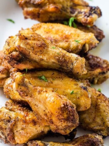 A stack of chicken wings that have been baked with a homemade dry rub on the wings.