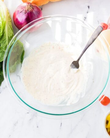 A glass bowl with mayonnaise to begin making a creamy sauce for hoagie dip.