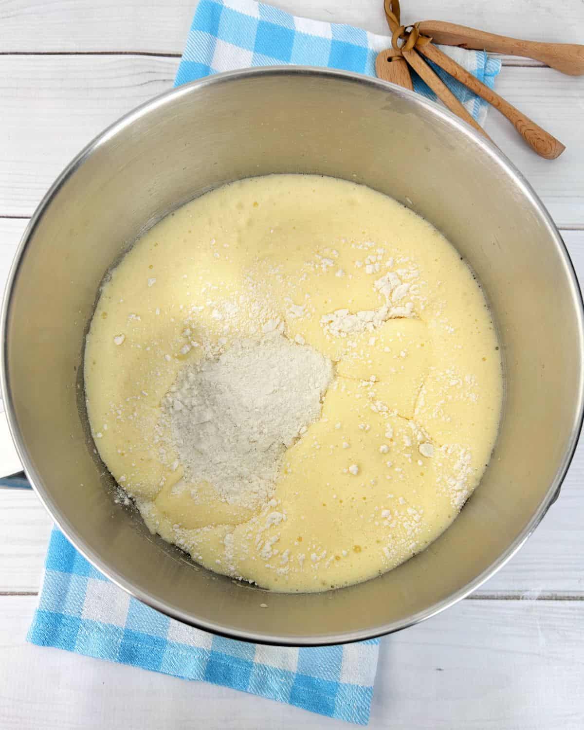 Lemon Swiss roll ingredients in a large bowl with eggs and flour.