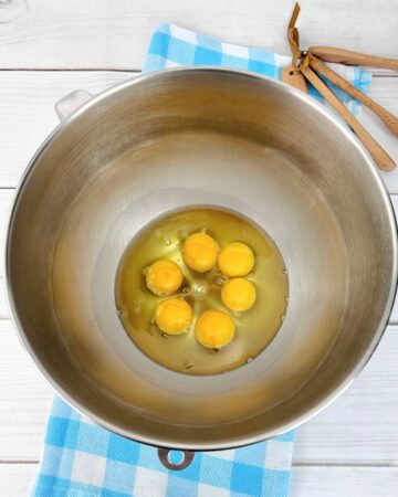 Eggs in a large mixing bowl to be made into lemon roll cake.