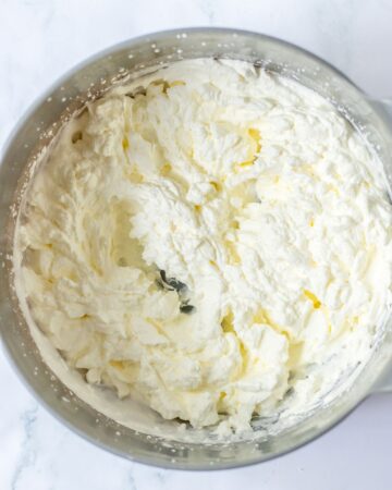 A stainless steel bowl with whipped heavy cream in the bowl. 