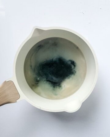 A large mixing bowl with candy sugar and black dye to make candy apples. 