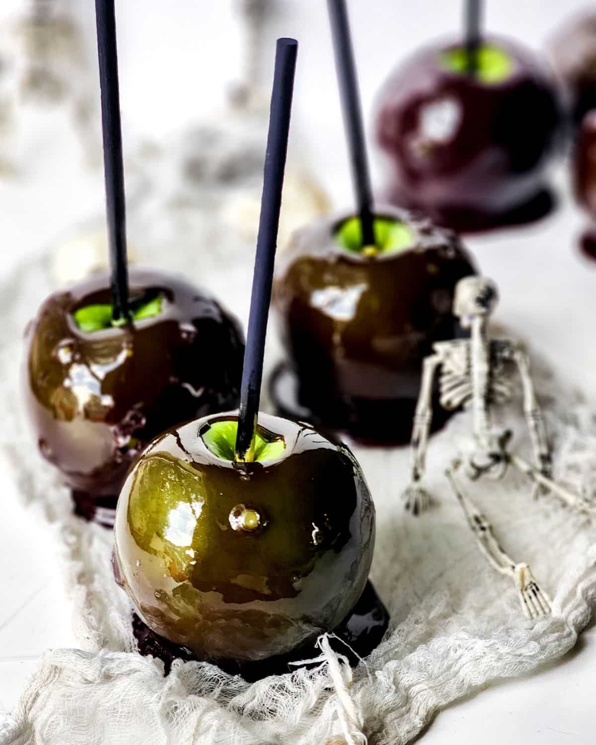Halloween candy apples with black candy coating on the apples. 