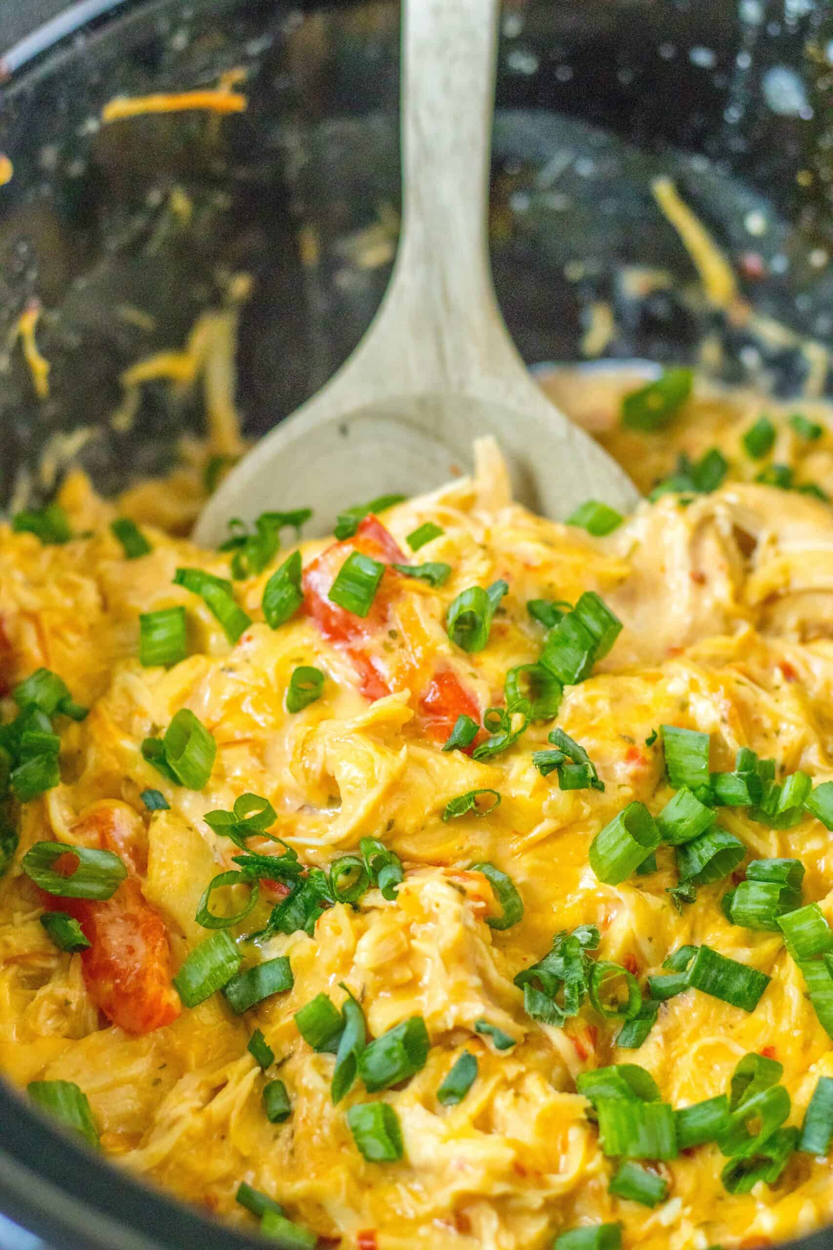 Slow cooker sweet chicken chili in a crock pot topped with green onions. 